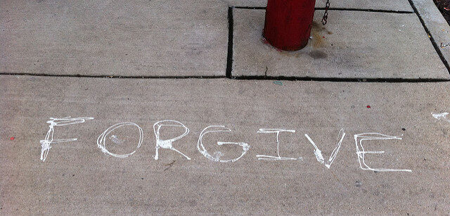 Word Forgive written in white on cement floor