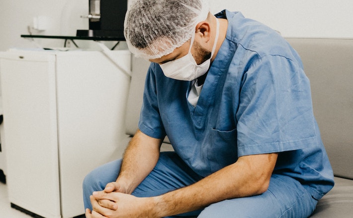 Man in scrubs praying