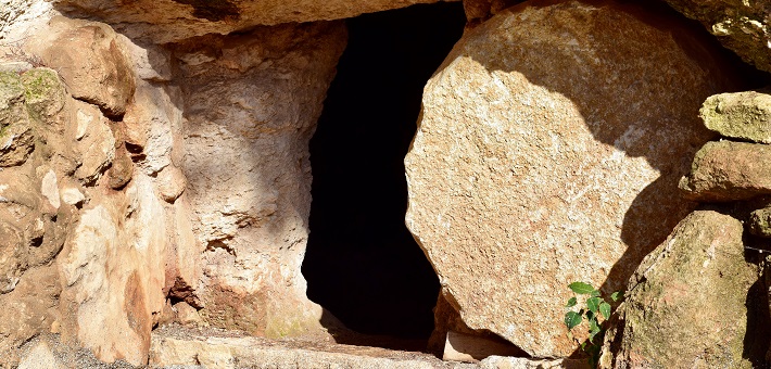 round stone in obscuring tomb entry