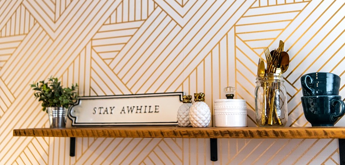 Stay Awhile sign on bookshelf