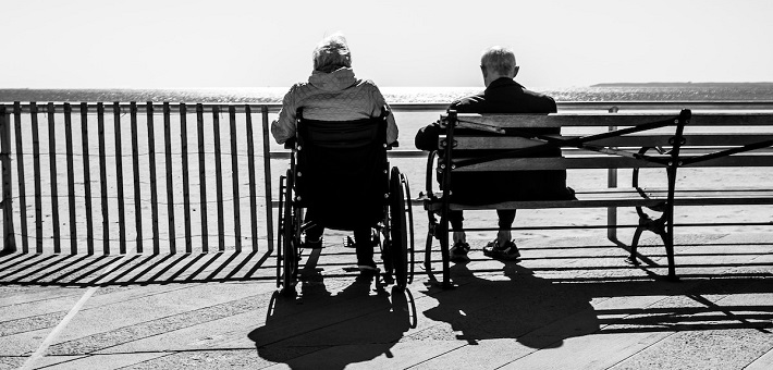 Elder adults sitting together on boardwalk