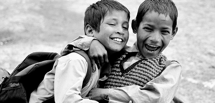 Two boys grasping each other and smiling