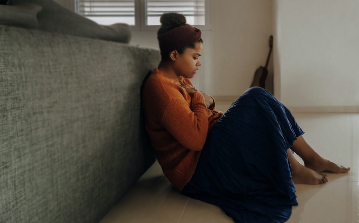 Woman sitting on floor in pain