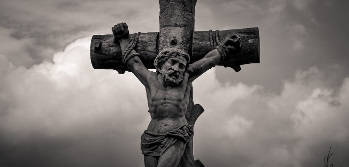 Stone crucifix against dark clouds