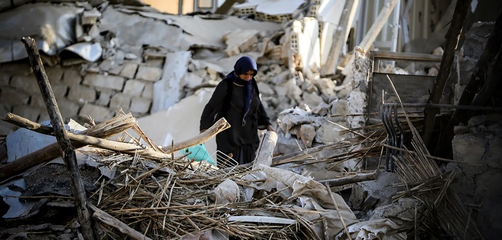 Figure standing amid rubble after earthquake