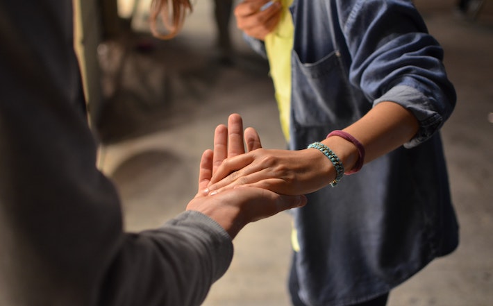 man and woman hold hand on street