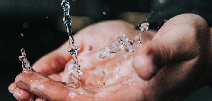 Hands receiving water splashing