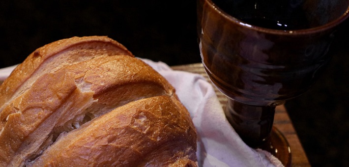 bread and wine on white cloth