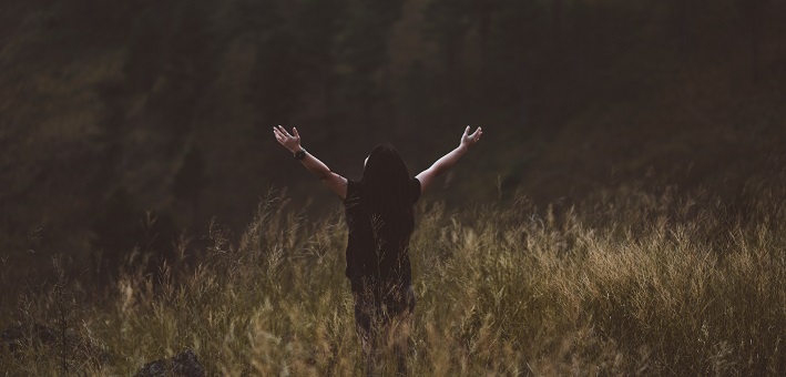 Man with hands outstretched in a field