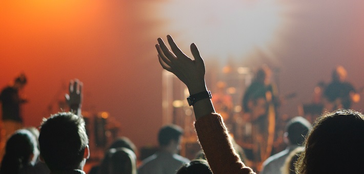 Hand raised in worship against orange background