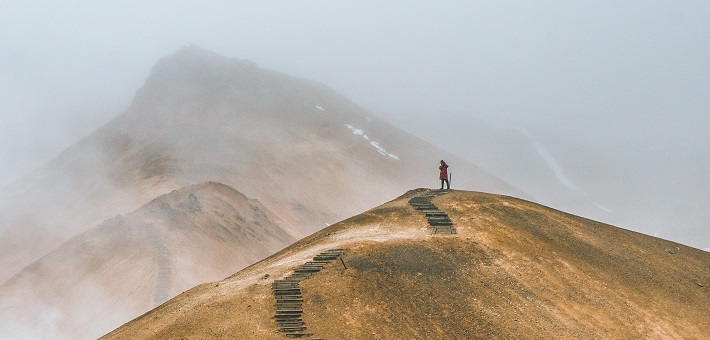 solitary walker on mountain path in cloud