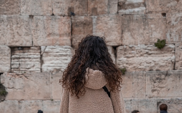 woman facing the Western Wall in Jerusalem