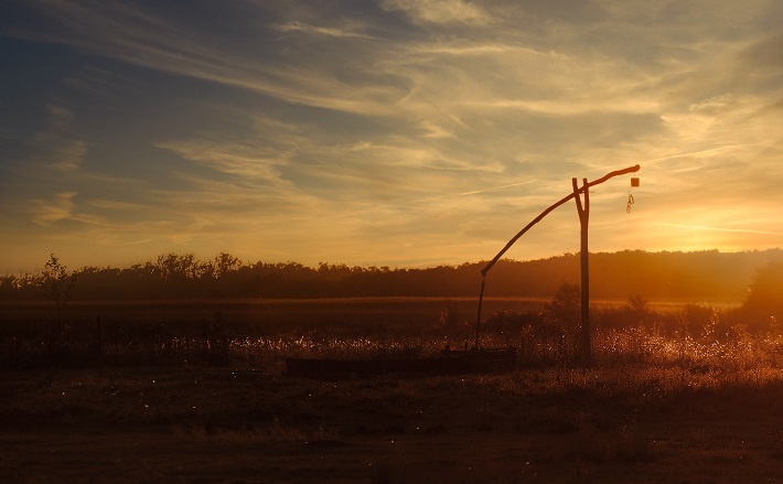 Well with hand pump at sunset