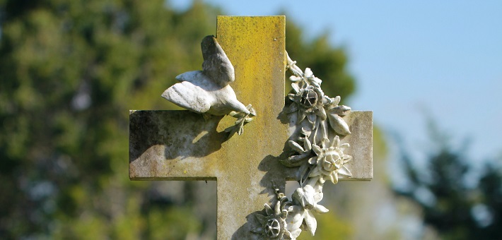 Stone cross with carved dove and floral decoration