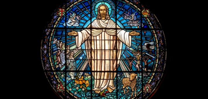 stained glass artwork of Jesus with His arms outstretched