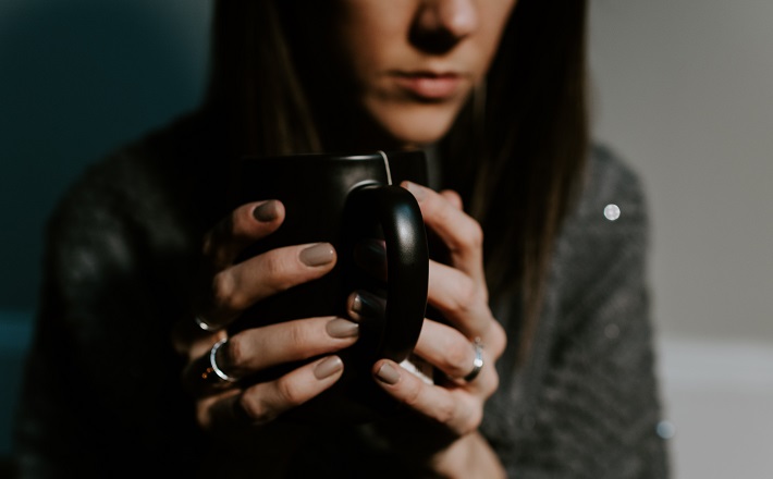 Woman holding mug with serious expression