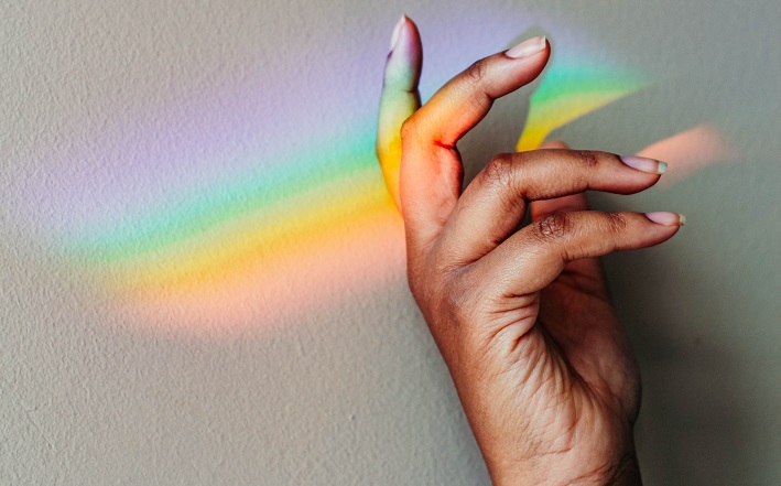 rainbow prism shining on a hand