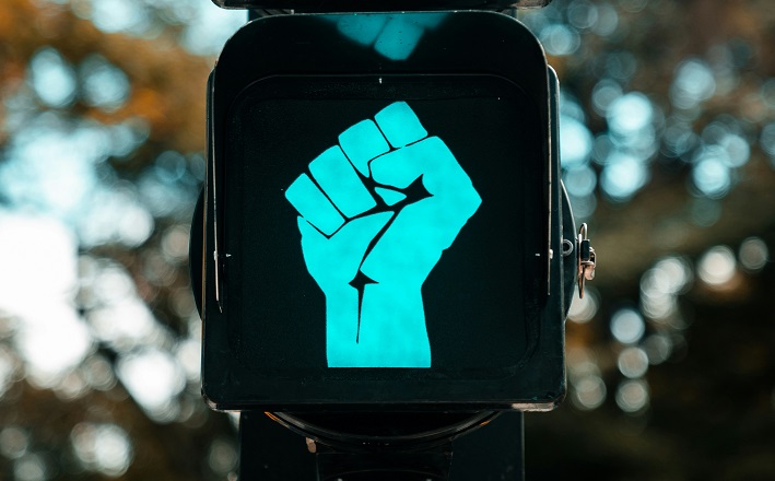 Green-light walk signal illuminated clenched fist