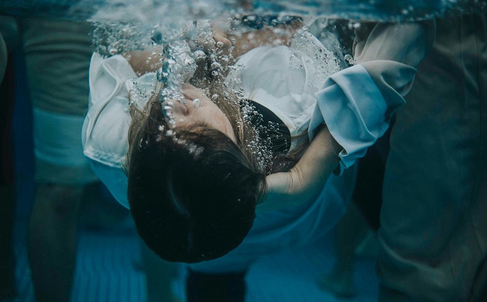 Underwater photo of woman being baptized by full immersion