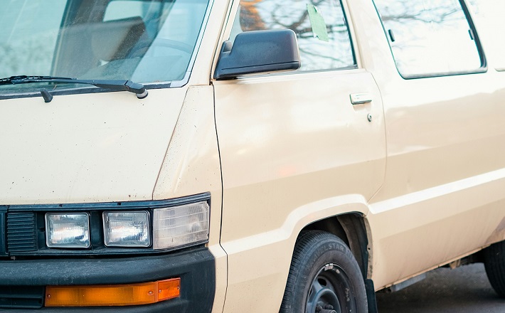 Old minivan with dents and scrapes