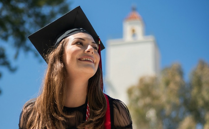 Grad standing in front of bell tower