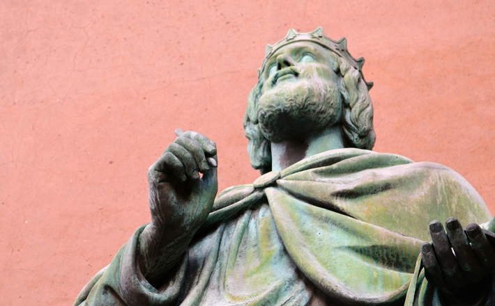 Bronze sculpture of King David against pink background