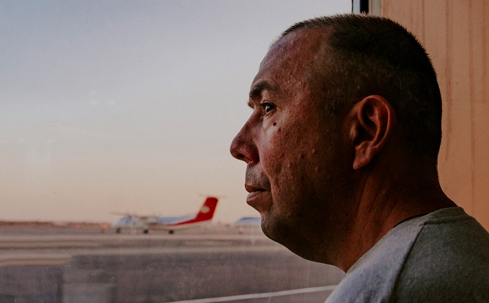 Man looking out window at airplane
