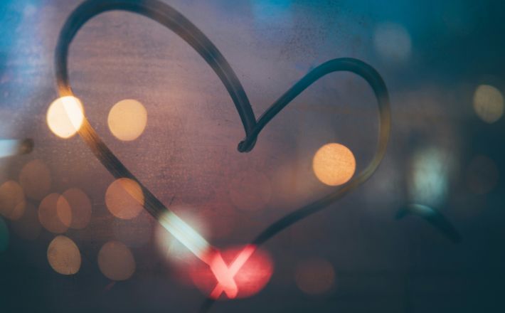 Preaching love - paper heart with fuzzy lights in background.