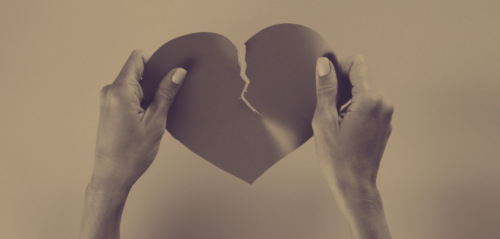 Photo of a paper heart being torn in two.