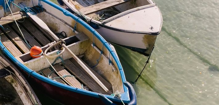 Two old boats tied along shore