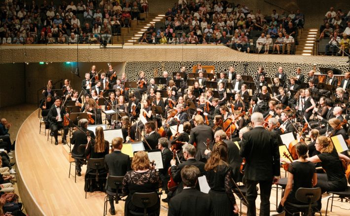 Orchestra standing on stage after performance
