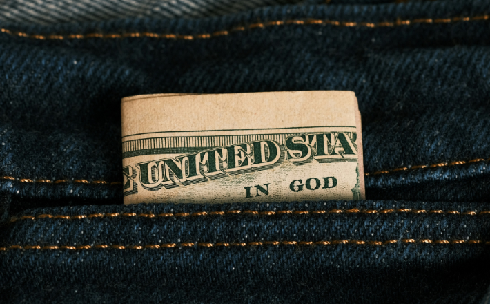 photo of a dollar bill in a backpocket with 
