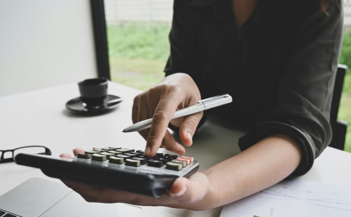 Person using handheld calculator to tabulate cost.