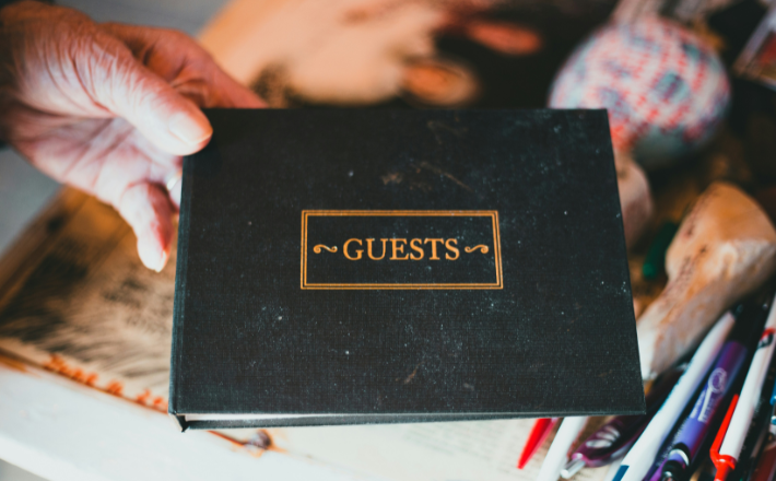 a hand holding a black book that reads 