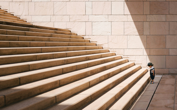 toddler standing in front of beige stairs