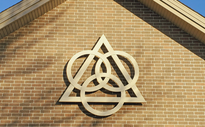A symbol of the Trinity on the outside of a church building.