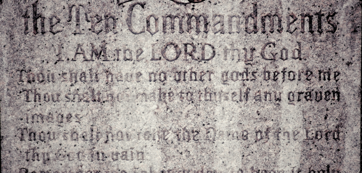 photo of a stone with the beginning of the ten commandments etched in