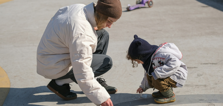 photo of an adult squatting down to be on the same level as a child
