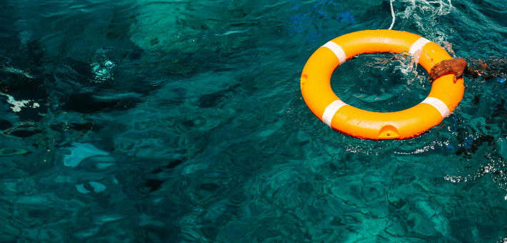 photo of an orange life preserver floating in the ocean