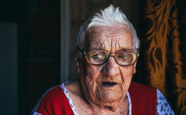 Old woman with glasses telling a story