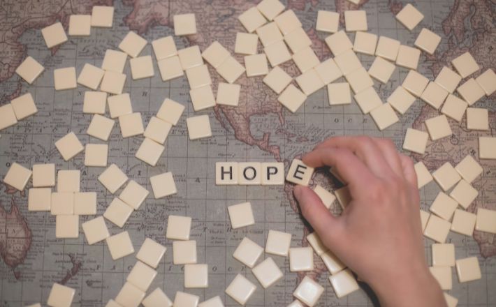 Scrabble letter spelling out HOPE on map of the Americas